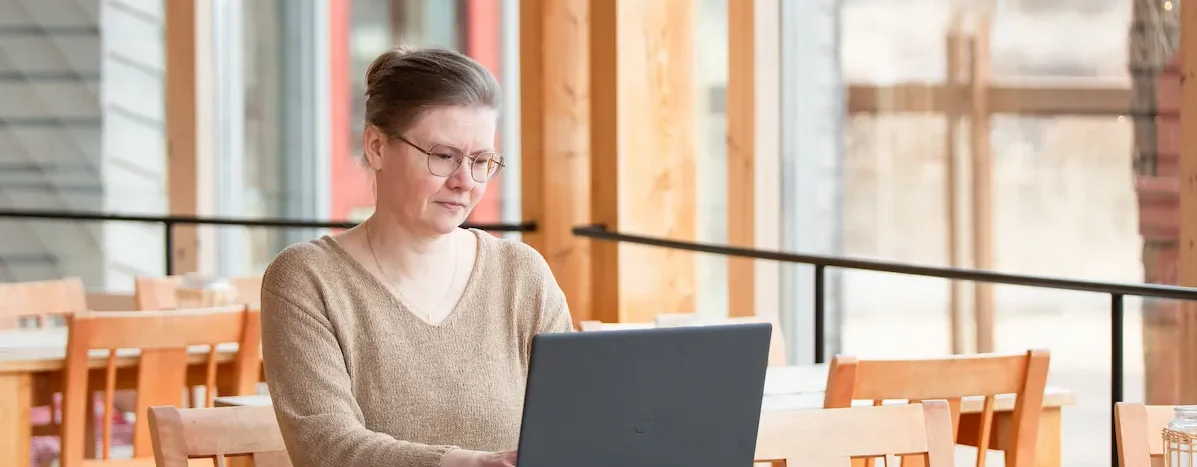 Kuvassa olen kirjoittamassa lisää blogeja tietokoneella