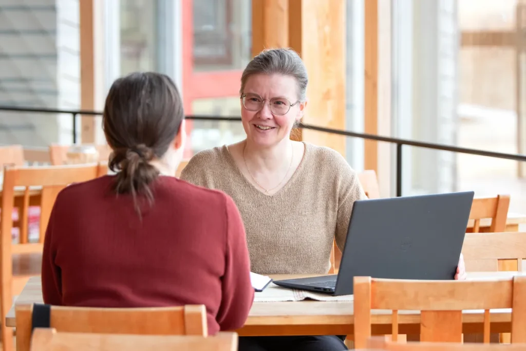 Työntekijät keskustelevat yhdessä työpöydän ääressä
